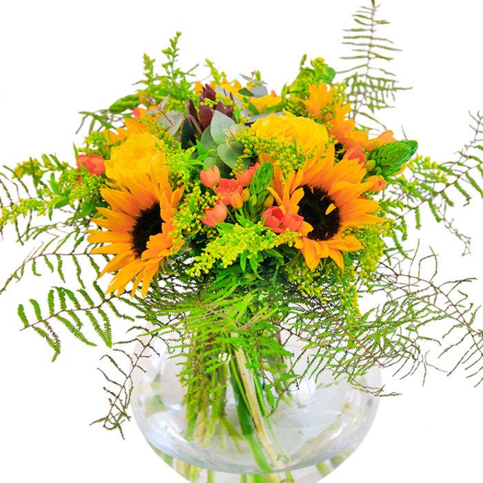 Radiating joy and seasonality, this lavish bouquet brings together the welcoming tones of golden sunflowers, yellow roses, and playful red berries in a celebration of Northwood's botanical richness. Towering sunflowers form the heart of the arrangement-their sunbeam-hued petals set against the velvety twilight of each brown core capture the sensation of a field in full bloom at Frithwood Park. Alongside, layers of tightly packed yellow roses provide a plush, tactile contrast, their perfume drifting softly in the air like the first hint of spring. Shimmering red hypericum berries are nestled between the larger blossoms, their lustrous skins popping against a tapestry of coiling ferns and bright green filler. Threads of slender, light-green flower spikes and the elegant, powdery tones of eucalyptus leaves contribute a gentle, rustic dimension. Displayed in a perfectly round glass vase, the stems are bathed in clear water-each line and structure visible, reinforcing the freshness and attention to detail characteristic of Flower Delivery Northwood. Ideal for uplifting birthdays, congratulating achievements, or simply filling a Northwood home with brightness, this piece sings with the artistry and warmth of a community-based florist who brings the subtle magic of nature indoors, one bouquet at a time.
